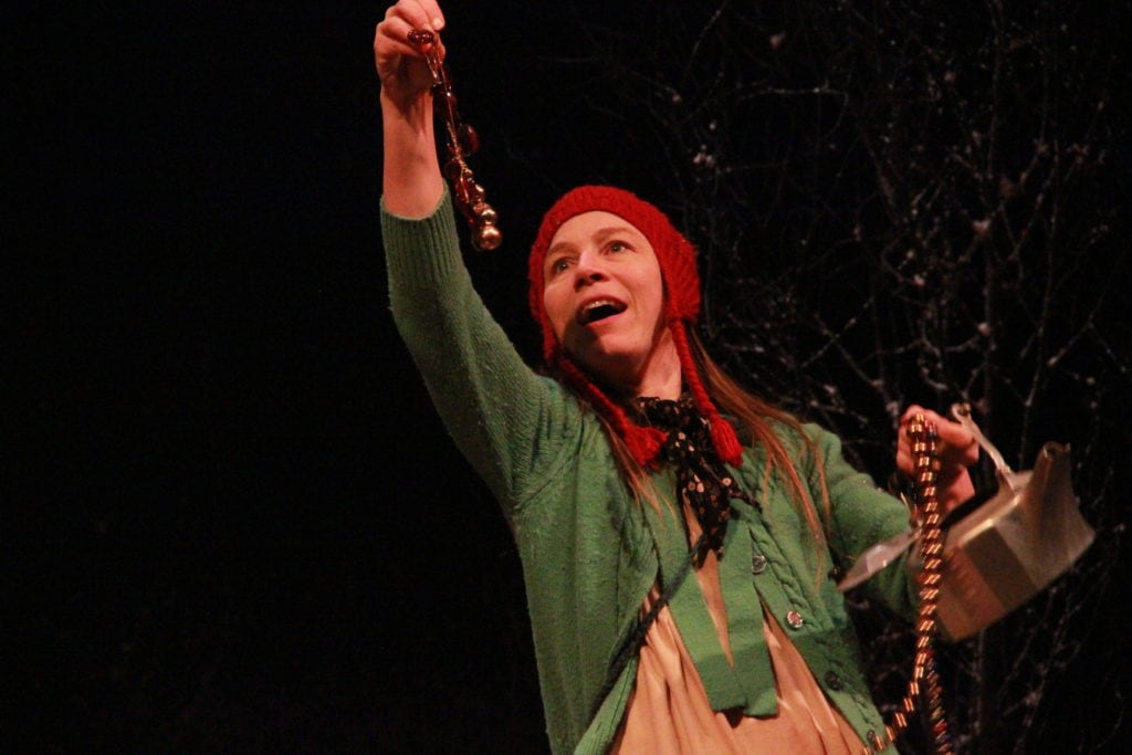 picture of female actress wearing red hat and green cardigan - portraying gretel in performance of Hansel and Gretel